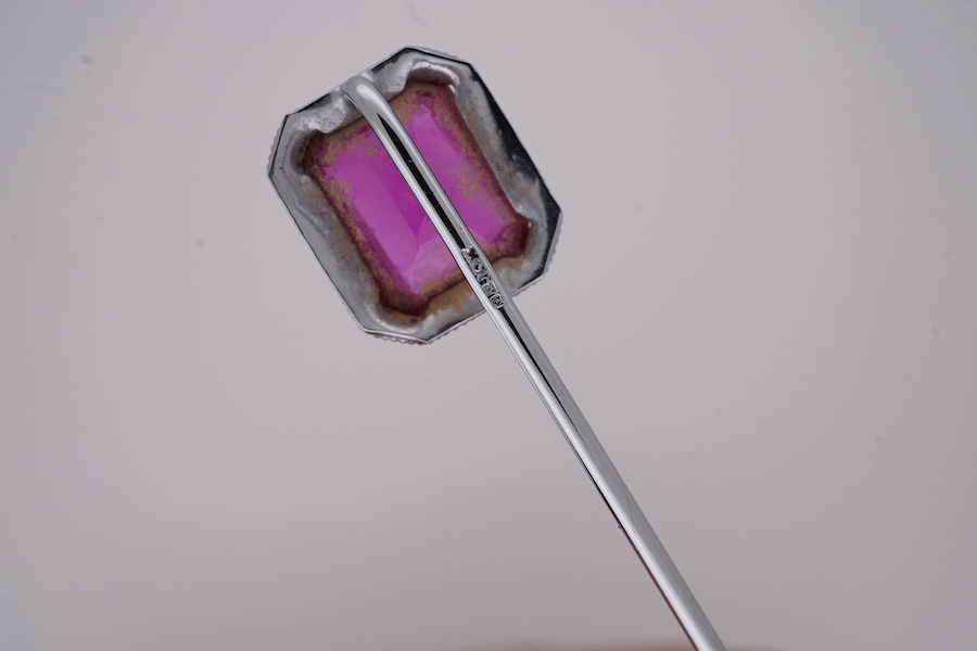 A North American? 10k white metal and single stone emerald cut synthetic ruby set stick pin, 55mm, gross weight 1.1 grams. Condition - fair to good